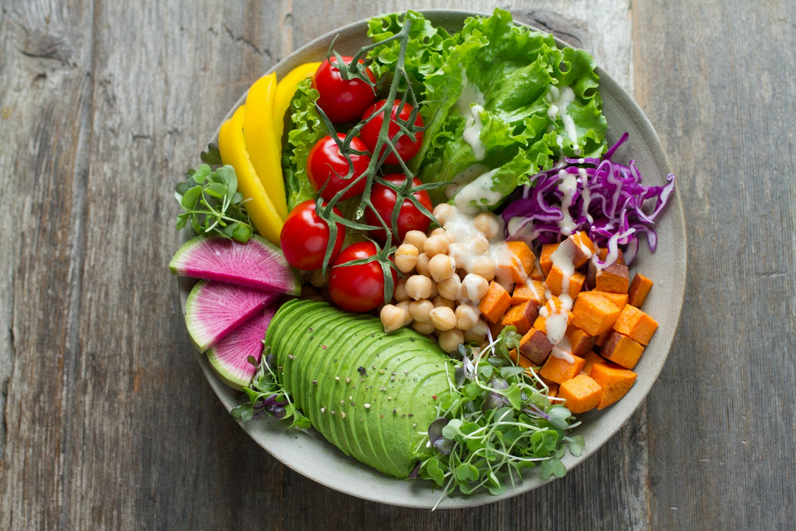 Frisch zubereitete vegane Gerichte — bunte Bowls und Salate aus saisonalem Gemüse